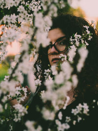 Portrait of young woman by flowering plants