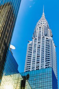 Low angle view of modern building against blue sky