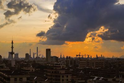 View of cityscape against cloudy sky