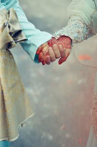 Close-up of newlywed couple holding hands