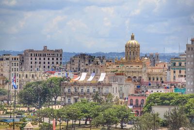 Buildings in city against cloudy sky