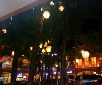 Low angle view of illuminated street lights at night