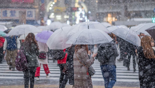 People walking on wet street during rainy season