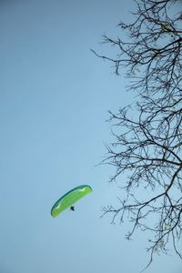 Low angle view of person paragliding against clear blue sky