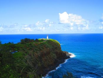 Scenic view of blue sea and mountain against sky