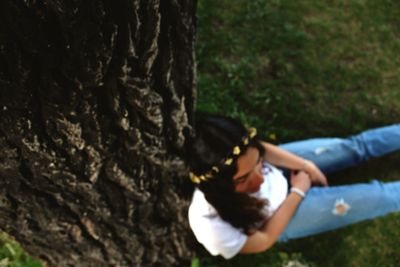 Close-up of girl on tree trunk