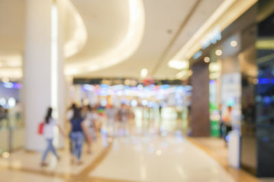 Defocused image of people walking on illuminated street