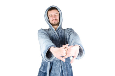 Portrait of young man standing against white background