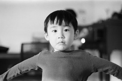 Portrait of boy standing against wall