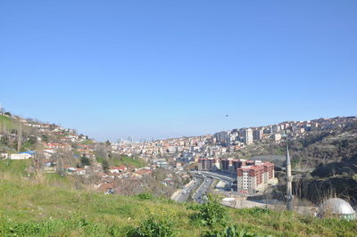 Buildings in city against clear blue sky