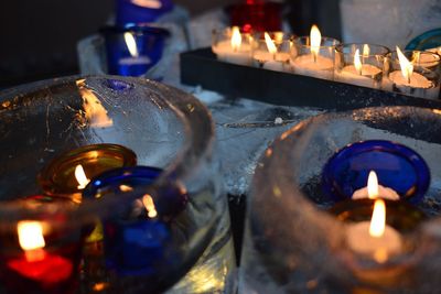 Close-up of lit candles in darkroom