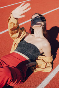 High angle view of woman lying down on running track