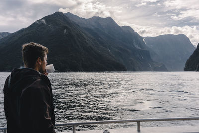 Man looking at mountains against sky