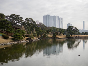 Scenic view of lake by buildings against sky