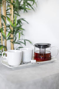 Close-up of coffee cup and jar on table