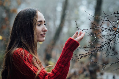 Improving mental wellbeing, relax and reduce stress. young woman in red sweater touching water