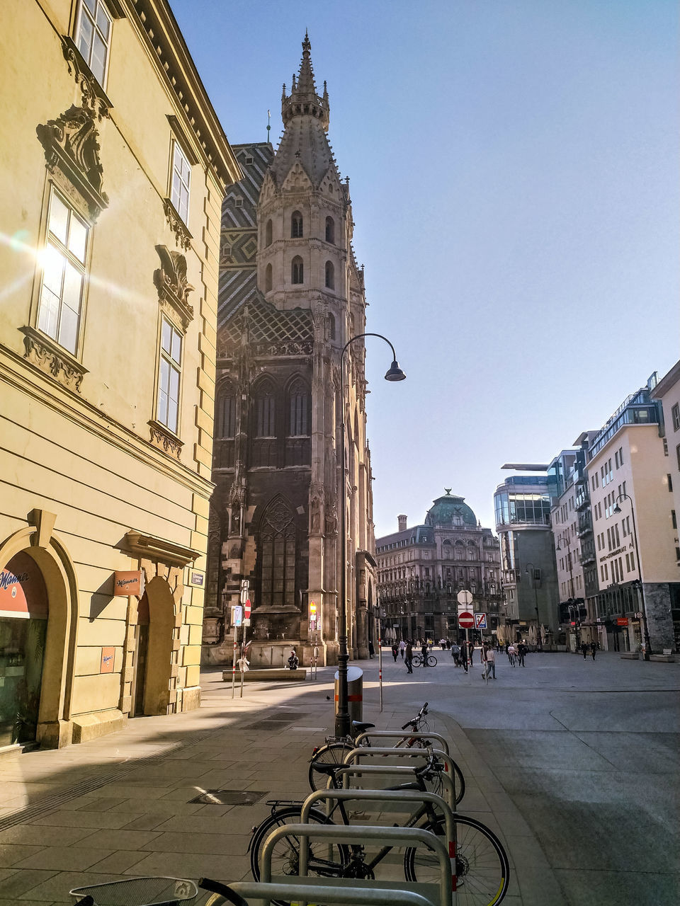 CITY STREET BY BUILDINGS AGAINST CLEAR SKY