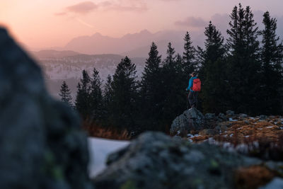 Girl watching the sunset from the mountain