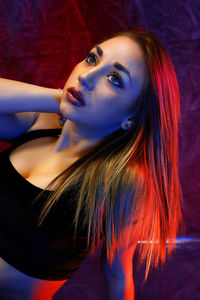 Close-up of a young blond woman posing in studio.