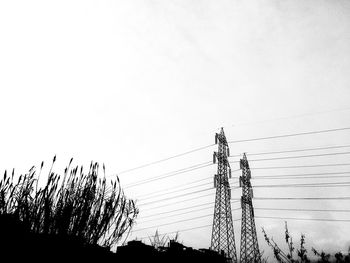 Low angle view of electricity pylon against clear sky