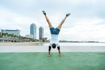 Low section of woman exercising at beach