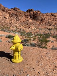 The stark contrast created by a lone fire hydrant and its surrounding red rock desert