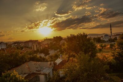 Houses in town against sky during sunset