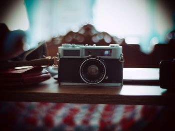Close-up of hand holding camera on table
