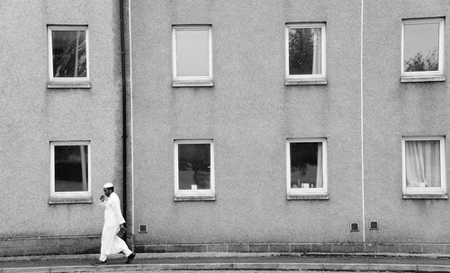 Rear view of woman standing against building