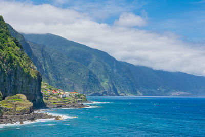 Scenic view of sea and mountains against sky