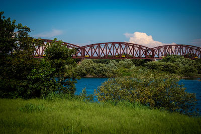 Arch bridge over river against blue sky