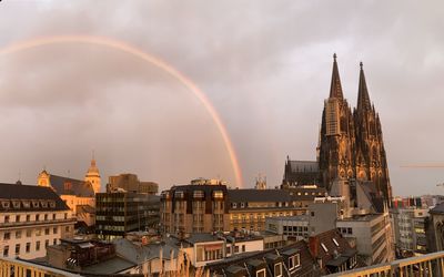 View of rainbow over buildings in city
