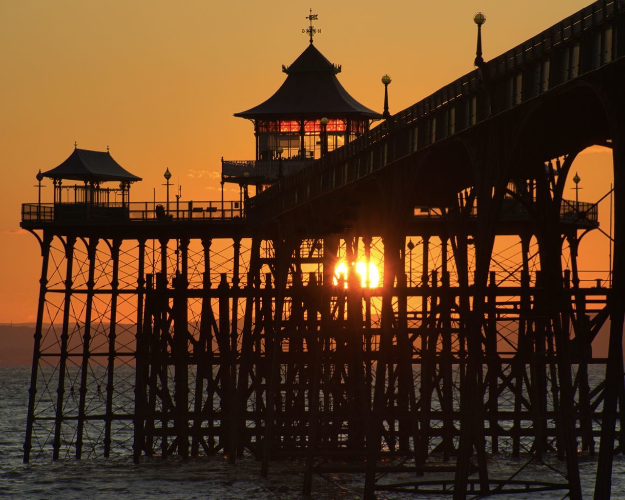 sunset, water, architecture, sky, built structure, evening, pier, dusk, nature, sea, silhouette, travel destinations, building exterior, reflection, beauty in nature, no people, sun, building, travel, tranquility, tourism, beach, scenics - nature, transportation, bridge, outdoors, stilt house, orange color, twilight, tranquil scene, land, idyllic, holiday