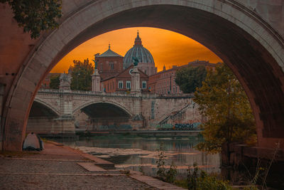 Arch bridge over river against building