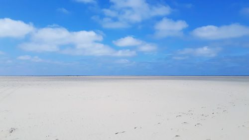 Scenic view of beach against blue sky