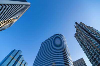 Low angle view of modern buildings against blue sky