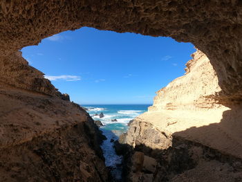 Scenic view of sea against sky seen through cave