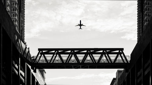 Low angle view of silhouette bridge against sky