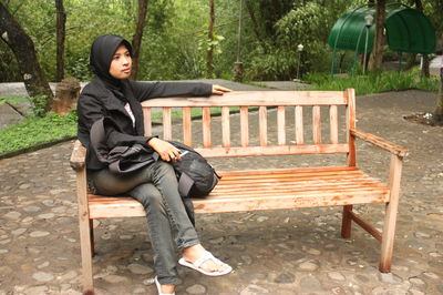 Woman sitting on bench in park