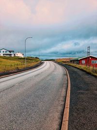 Empty road against cloudy sky