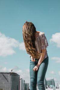 Rear view of woman standing against sky