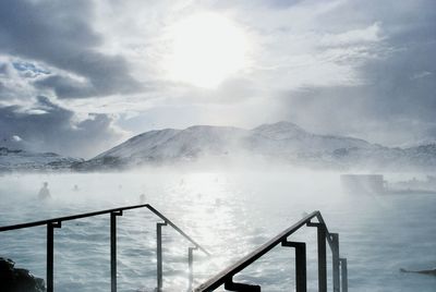 People in hot spring against sky