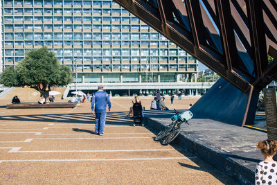 People walking by building in city