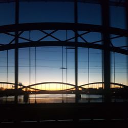 Silhouette of suspension bridge against sky during sunset