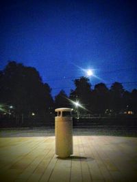 Illuminated street light against sky at night