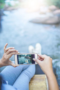 Midsection of man using mobile phone