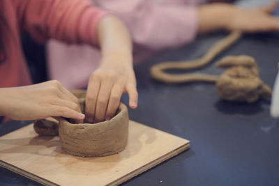 Cropped image of hands making pottery from clay

