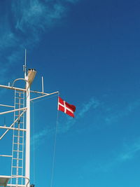Low angle view of flag against blue sky