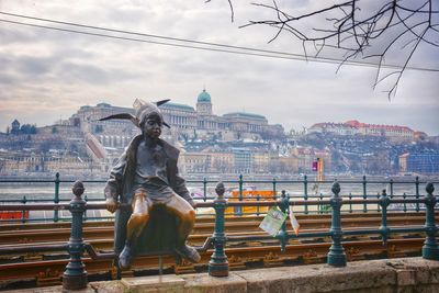 Statue of buildings against cloudy sky