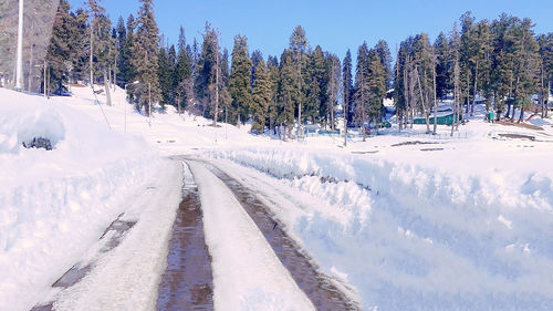 Panoramic shot of snow covered road against sky